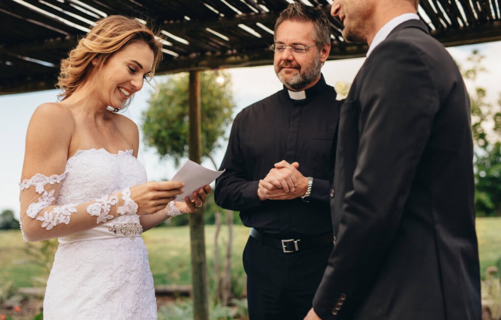 Bride reading vows during outdoor wedding ceremony.