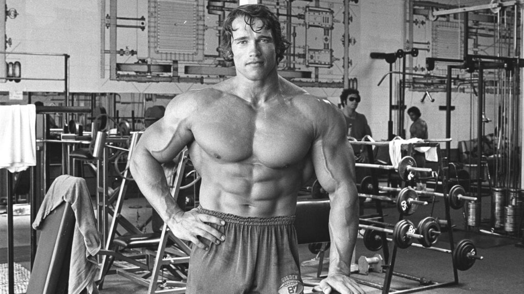Bodybuilder posing in a gym setting.