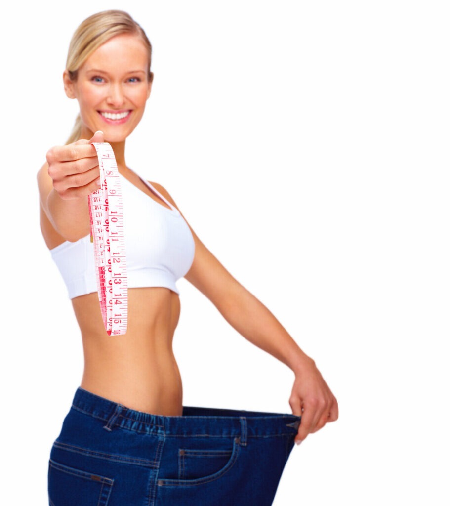 Woman holding tape measure, wearing loose jeans.