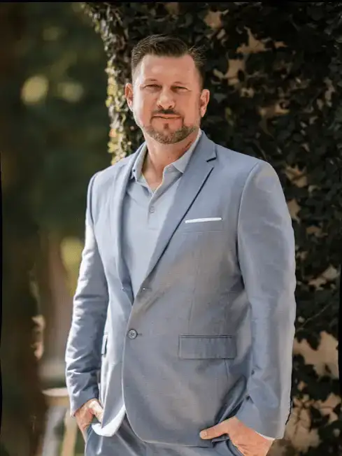 Man in light blue suit outdoors.